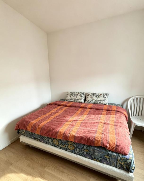a bedroom with a bed and a chair at Studio Maisons-Alfort in Maisons-Alfort