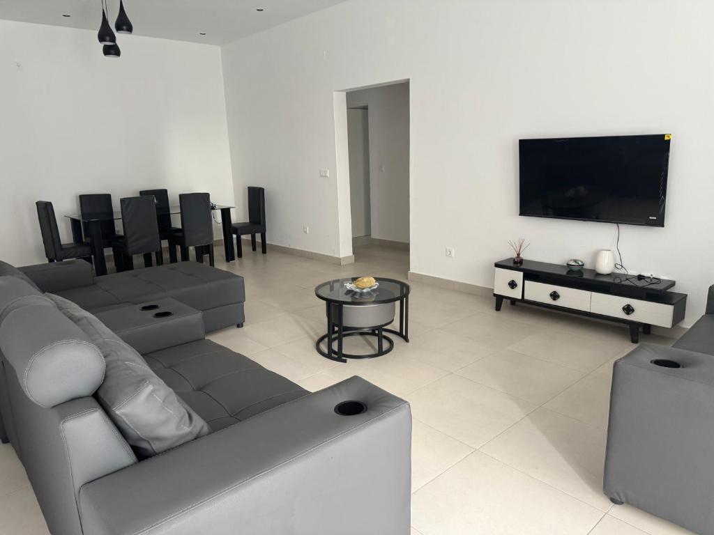 a living room with a couch and a tv at Flora House in Maputo