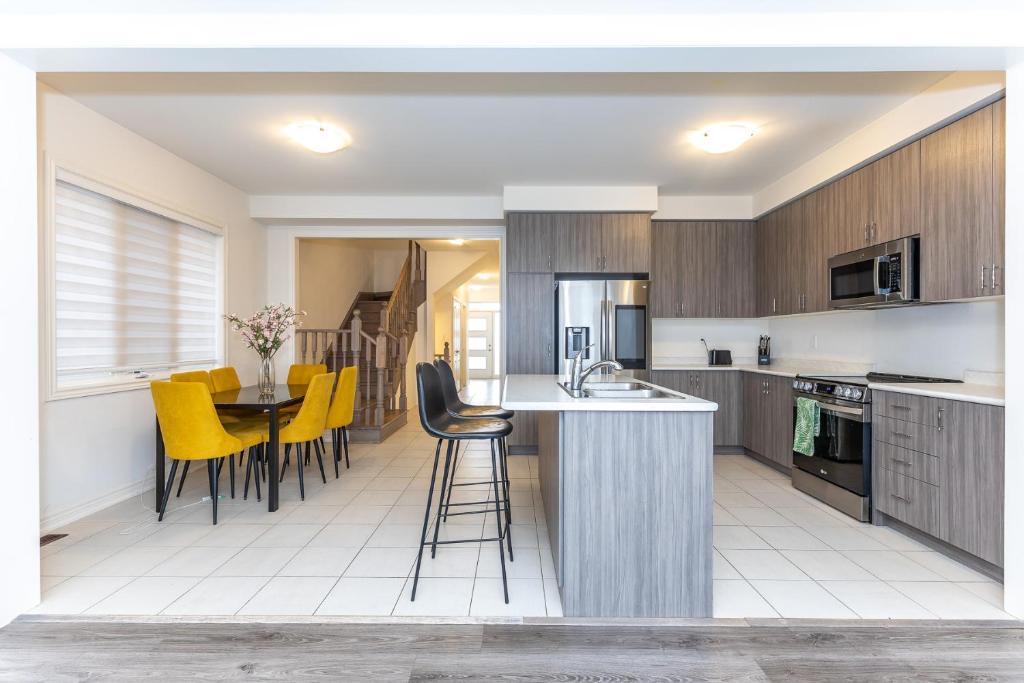 an open kitchen with yellow chairs and a counter top at Home in Waterdown in Hamilton