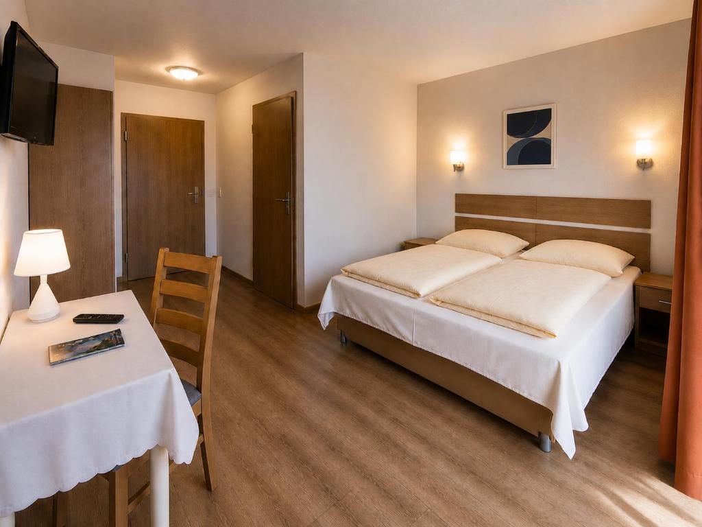 a hotel room with a bed and a table and a desk at i-Motel Obertshausen nahe Frankfurt in Obertshausen