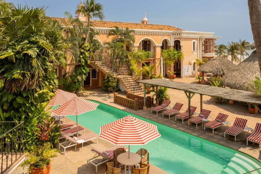 an outdoor swimming pool with chairs and umbrellas at Hotel Santa Fe in Puerto Escondido