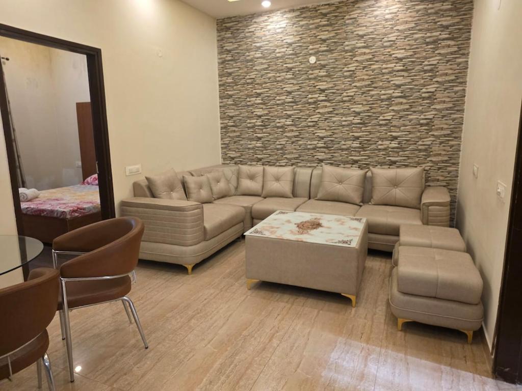 a living room with a couch and a brick wall at The Cozy Theory in Kharar