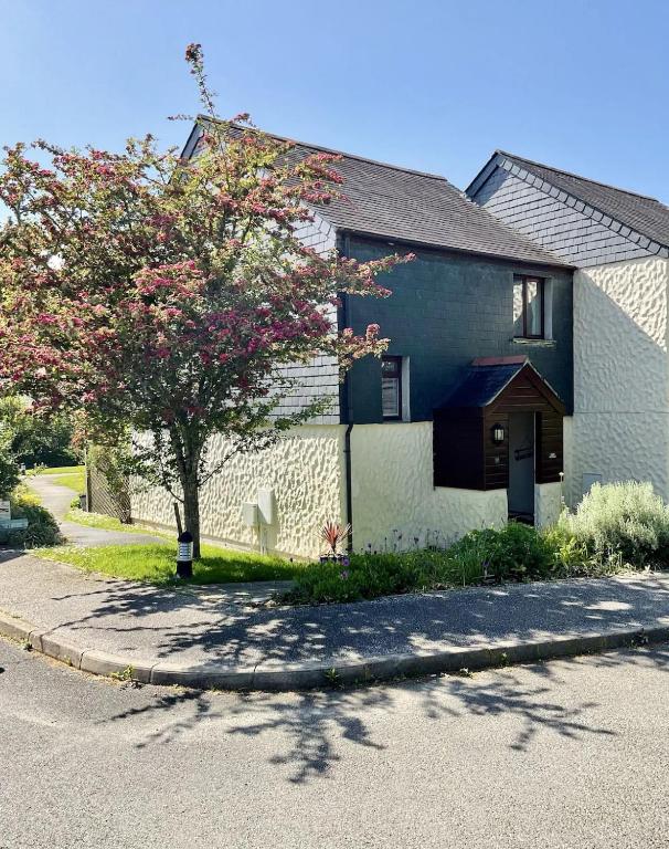 a house with a tree on the side of a street at Yarg Cottage in Falmouth