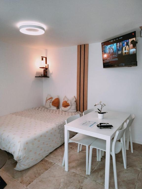 a bedroom with a bed and a table and a tv at Duplex Hyper centre-ville 10 in Quimper