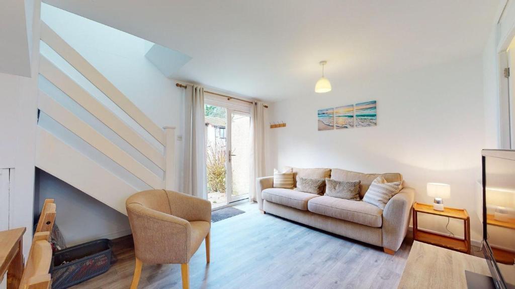 a living room with a couch and a chair at 39 Strawberry Hill, Tolroy Manor in Hayle