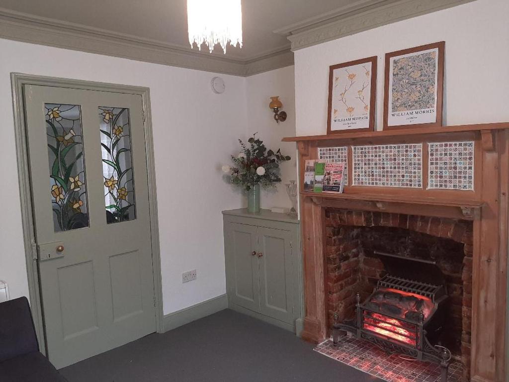 a living room with a fireplace and a door at Quirky hideout in town centre in Wimborne Minster