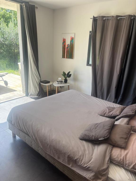 a bedroom with a bed and a large window at Maison agostini in Zonza
