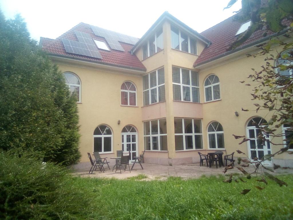a large house with tables and chairs in front of it at Villa Panorama in Biatorbágy