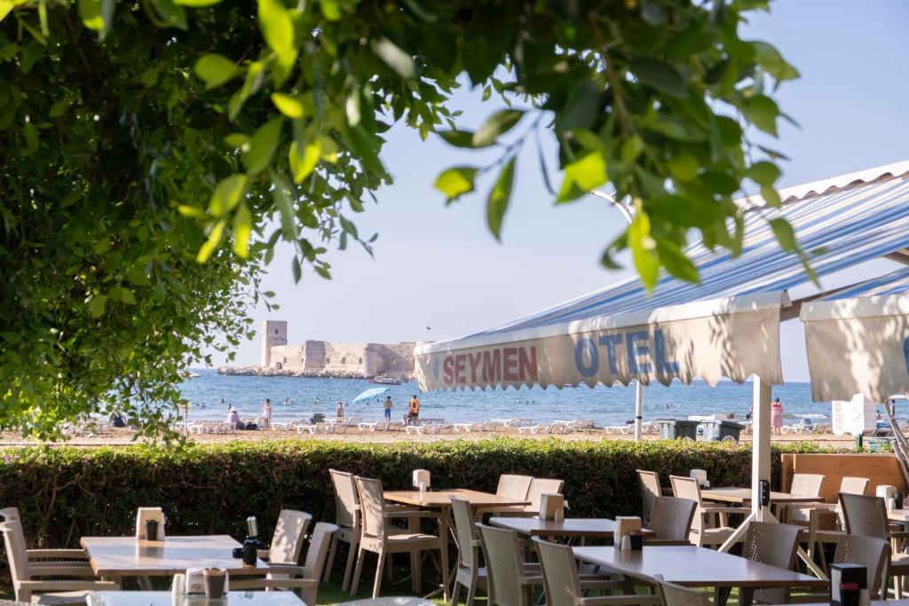 a row of tables and chairs at a beach at Seymen Otel in Kizkalesi