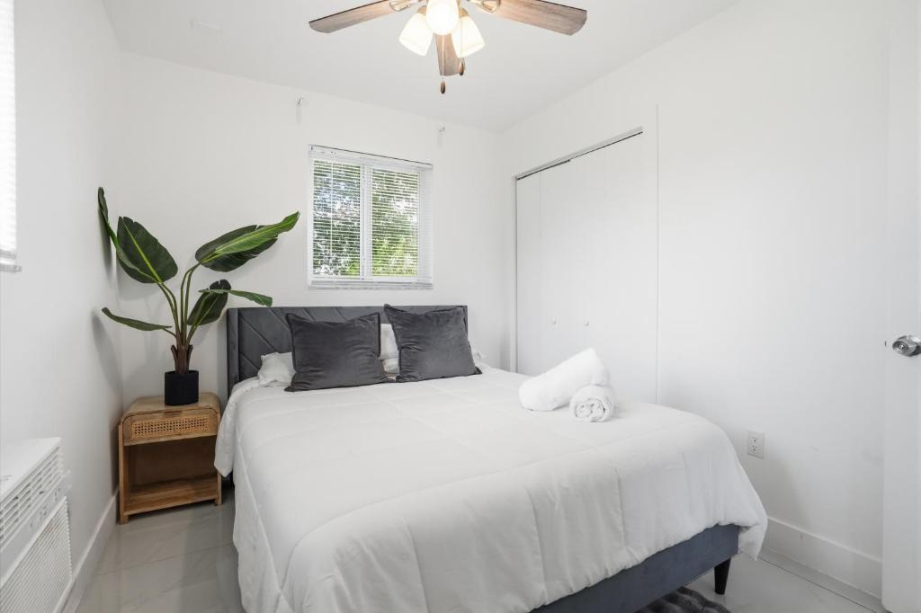 a white bedroom with a bed and a ceiling fan at 11430 Lincoln Blvd in Richmond Heights