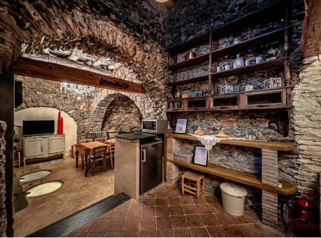 a kitchen with a stone wall with a stove in it at Soqquadro Art&Relax Alassio - Romantico Frantoio 1600 in Alassio