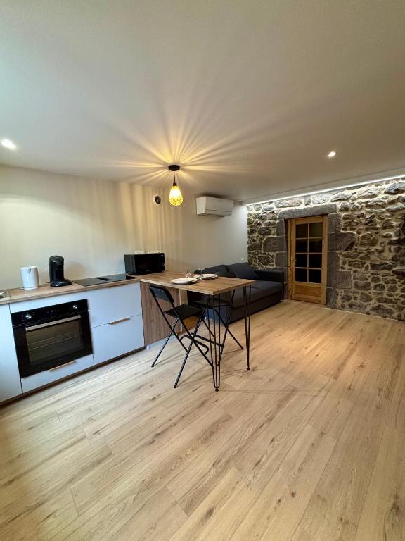 a kitchen and a living room with a table at Charmant studio en Auvergne in Orcines