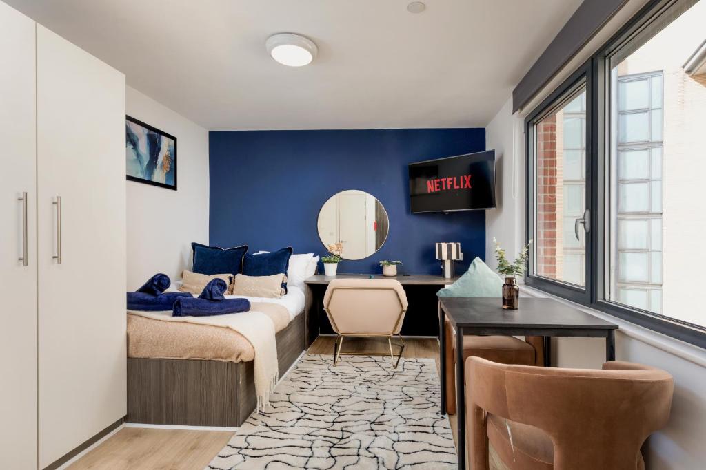 a bedroom with a bed and a desk with a mirror at Stylish City Centre Studio, Sleeps 2 in Sheffield