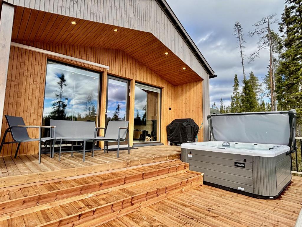 a deck with a pool table and chairs on a house at Peaceful Cabin with Hot Tub and Nature Views, Villa Lakeside Ruka in Ruka