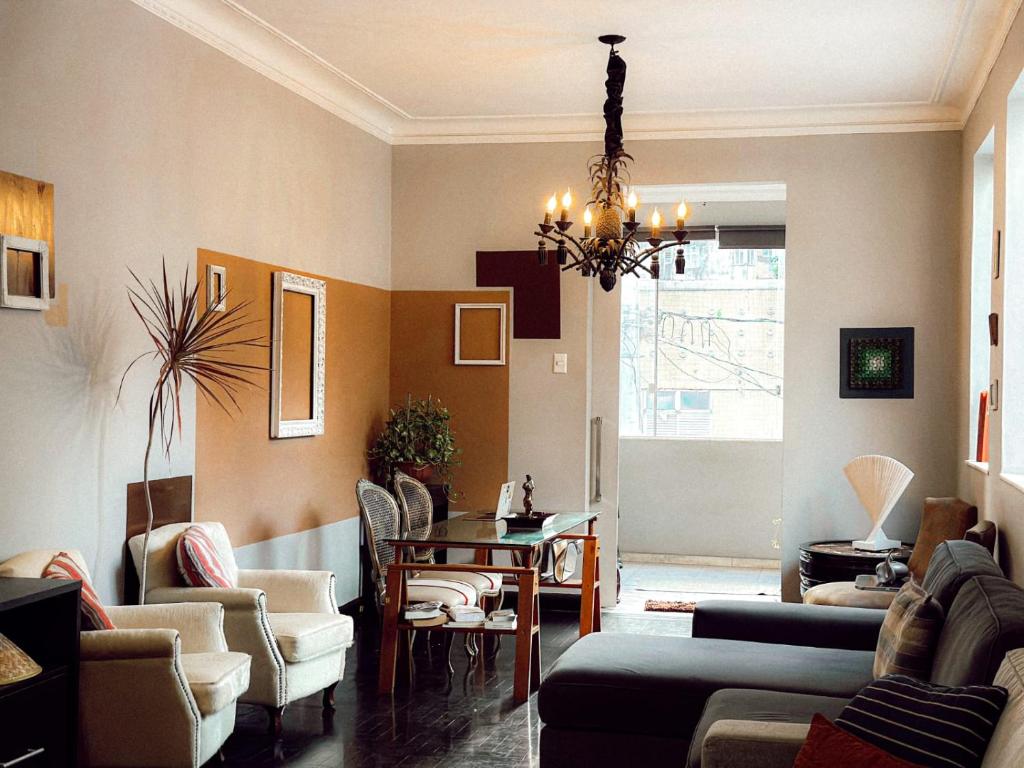 a living room with a chandelier and a table and chairs at Hostel Triplo J e Guest House in Salvador