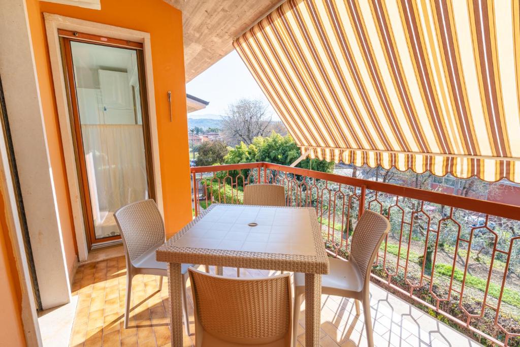a balcony with a table and chairs on a balcony at Appartamento x 4 con wi-fi, park free, a 10 minuti dal centro di Garda in Garda