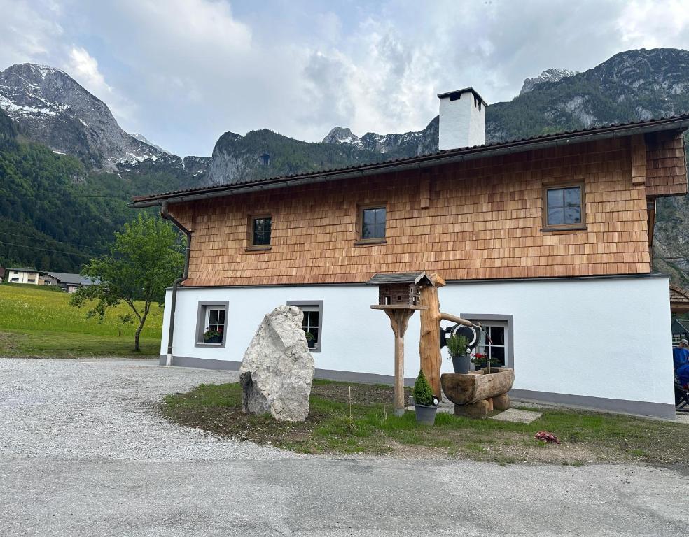 a large white building with a rock in front of it at Ferienwohnung Loifried in Abtenau