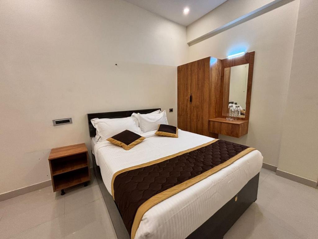 a bedroom with a large bed and a mirror at Thamira Grand palace in Agastīswaram