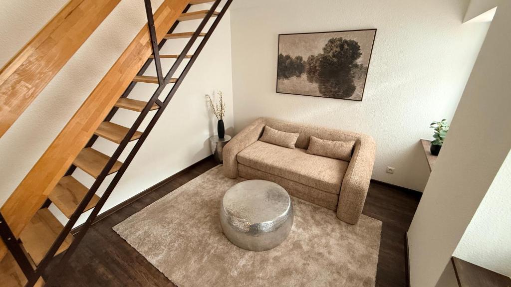 a living room with a couch and a stair case at Amara in Siegburg