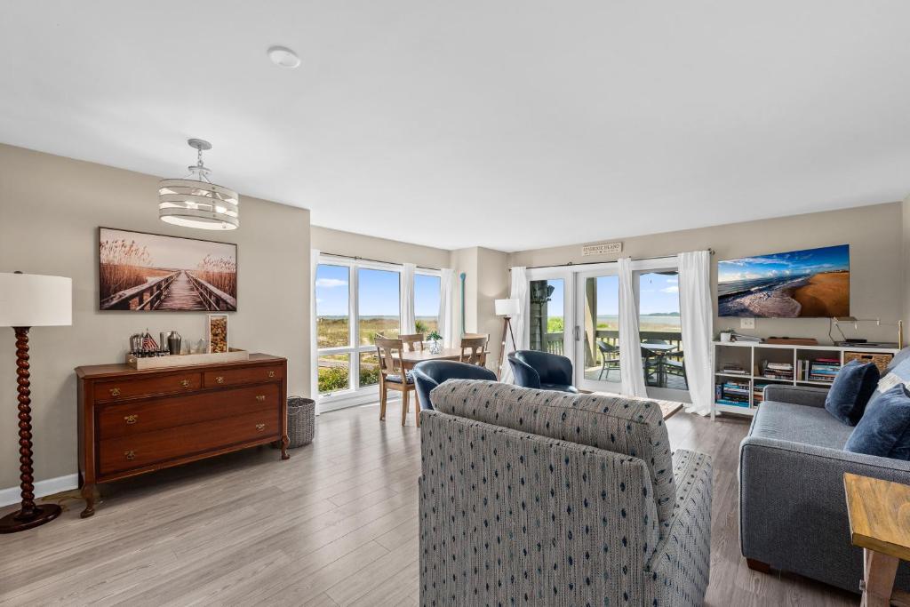 a living room with two couches and a table at 1325 Pelican Watch Villa in Seabrook Island