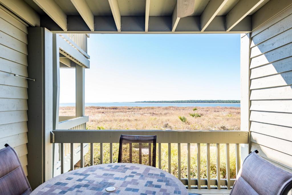a balcony with a table and a view of the ocean at 1317 Pelican Watch Villa in Seabrook Island