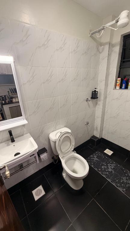 a bathroom with a white toilet and a sink at Pinnacle Homes 254 - Ruaka in Ruaka