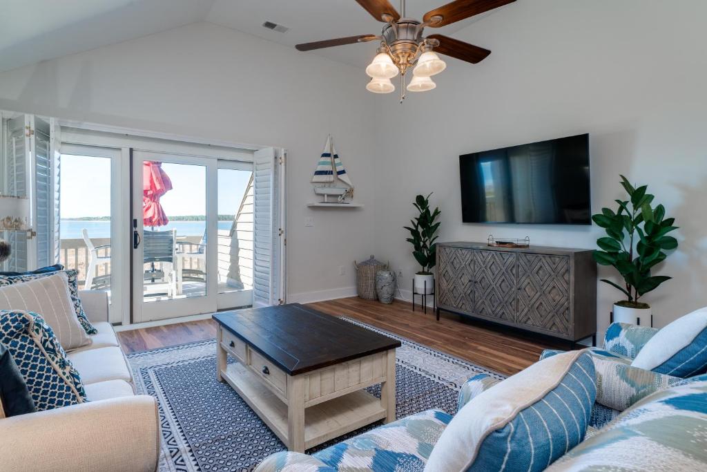 a living room with a couch and a flat screen tv at 1306 Pelican Watch Villa in Seabrook Island