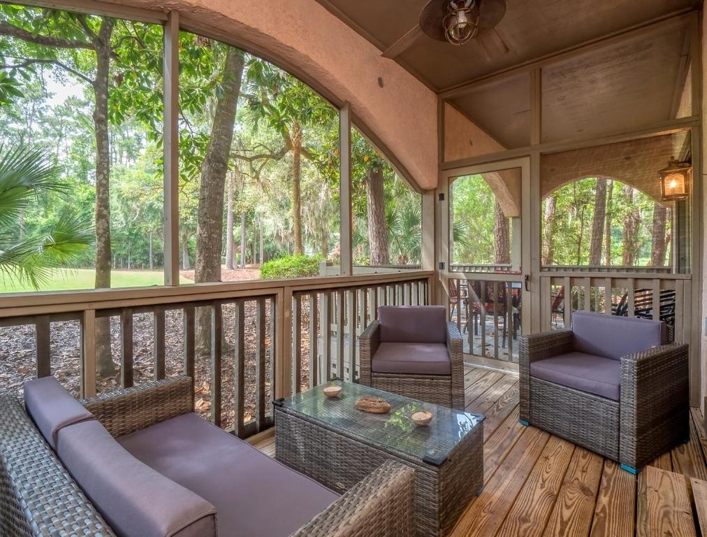a screened in porch with chairs and a table at 2502 Chateau by the Green in Seabrook Island