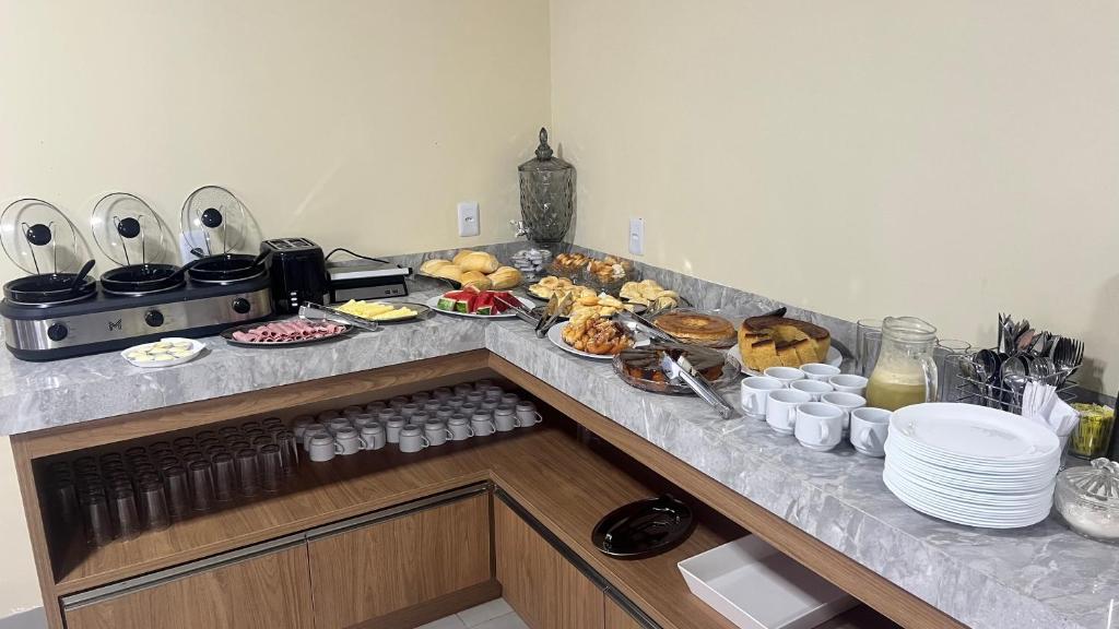 a kitchen counter with a bunch of food on it at Hotel Rocha in Novo Acordo