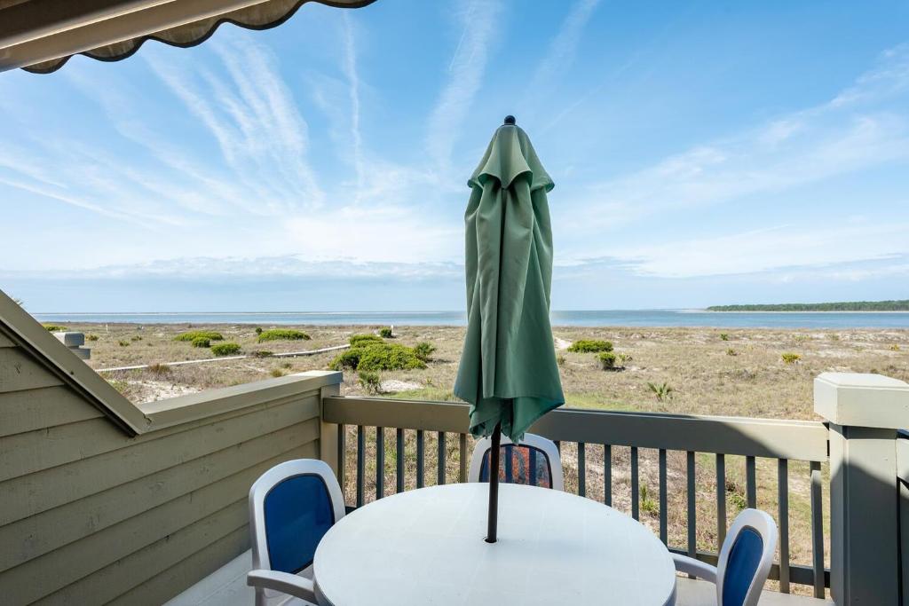 a patio with a table and an umbrella at 13108 Pelican Watch Villa in Seabrook Island