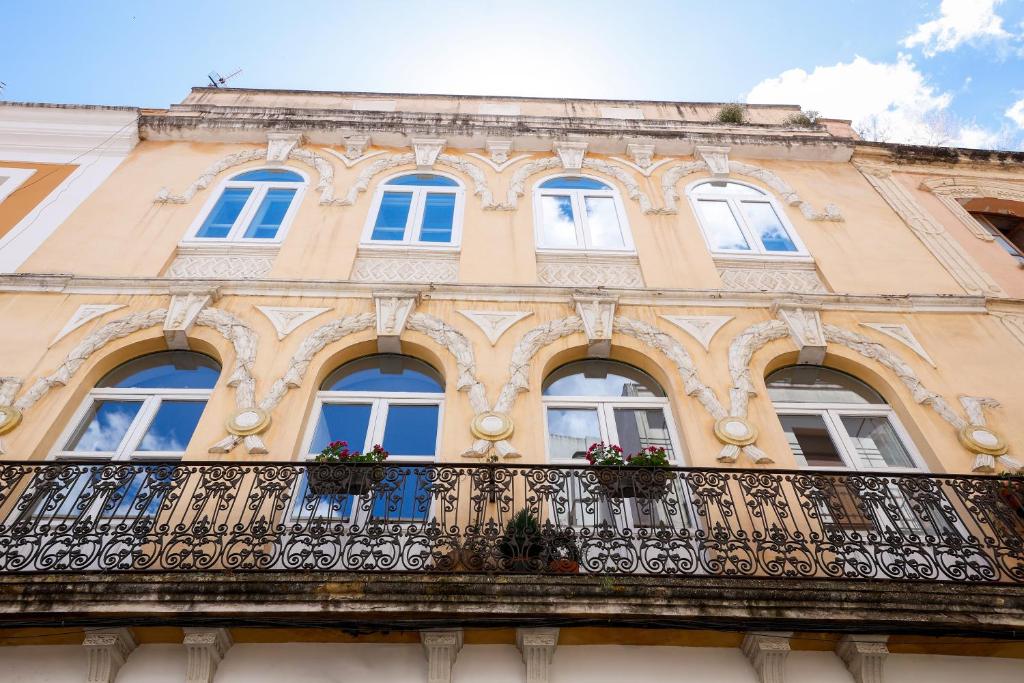 an old building with windows and a balcony at La Casa de Claudio Marcelo in Córdoba