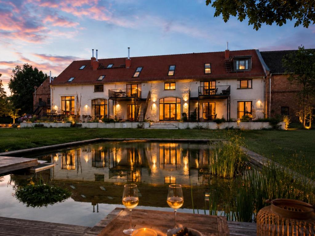 a house with a pond in front of it at Landloft Linum in Fehrbellin