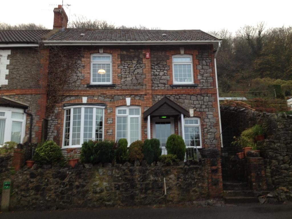 a brick house with a stone wall at Stunning coastal cottage in Worle