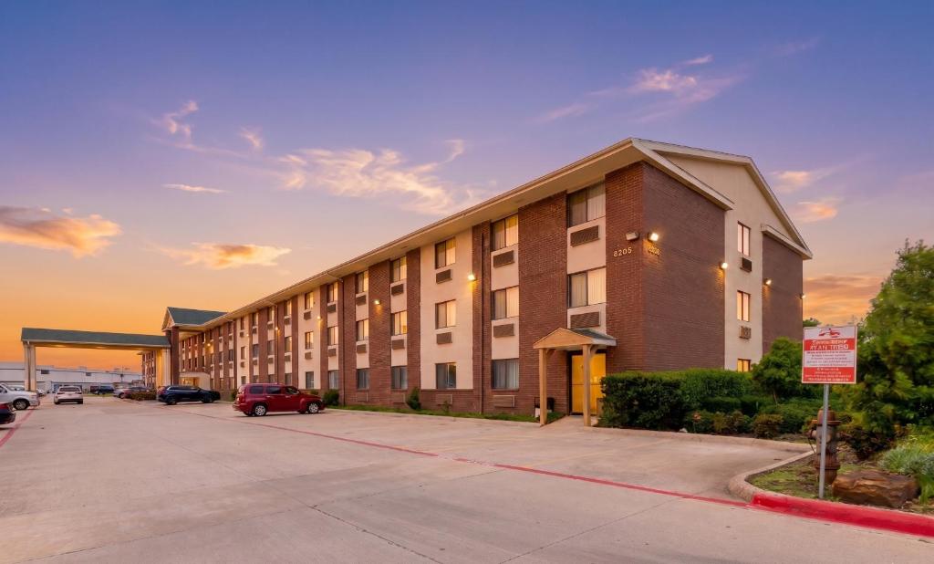 a large building with a parking lot in front of it at Quality Inn DFW Airport North in Irving