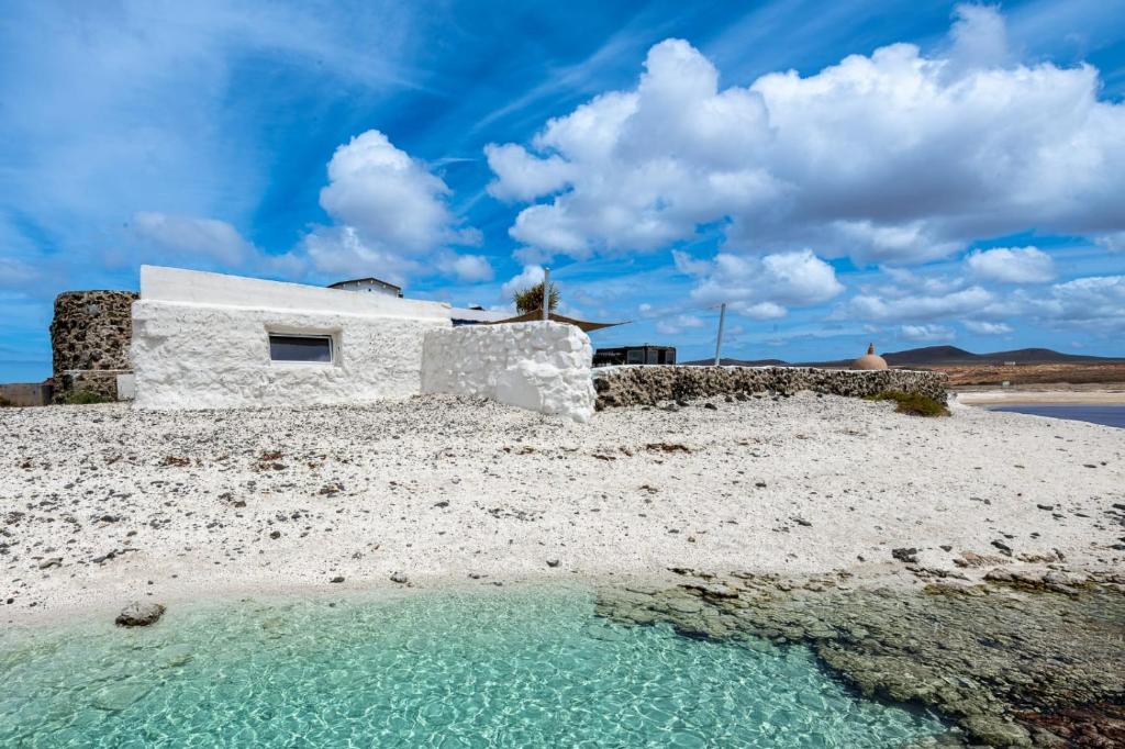 a house on the beach with a pool of water at Vista Paraiso, Sea breeze facing the sea in La Oliva