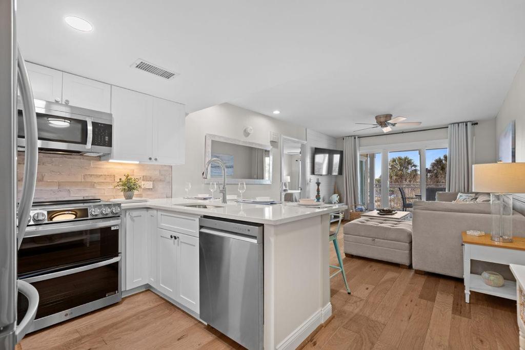 a kitchen with white cabinets and a living room at 2943 Atrium Villa in Seabrook Island