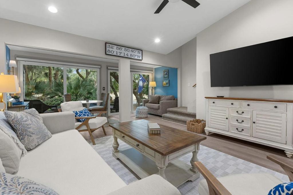 a living room with a white couch and a tv at 620 Shadowwood in Seabrook Island