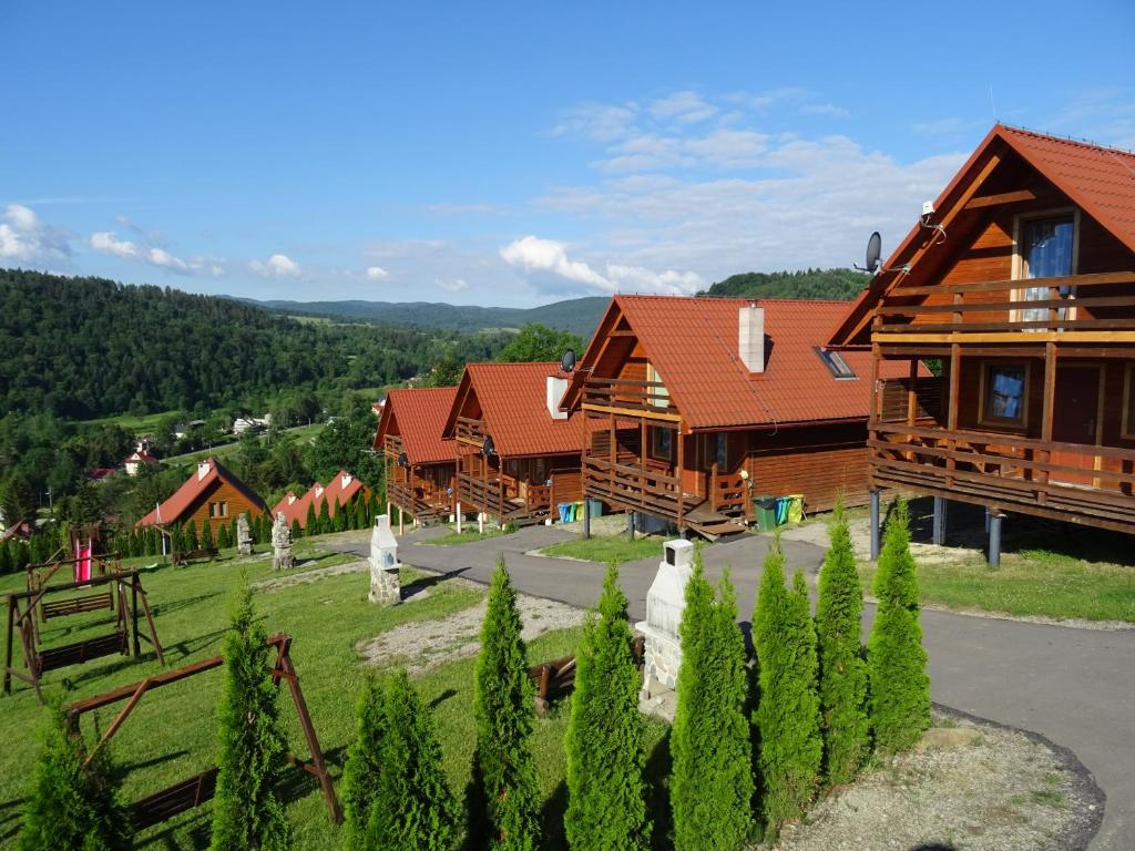 a row of wooden cabins in a village at Domek Bieszczady Wolkowyja 2 nad Solina in Wołkowyja