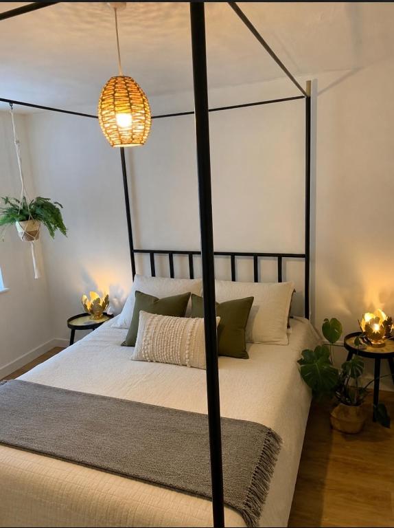 a bedroom with a black canopy bed with two tables at Cartref 2 Double Bed Apartment Nebo Dogs Welcome in Amlwch