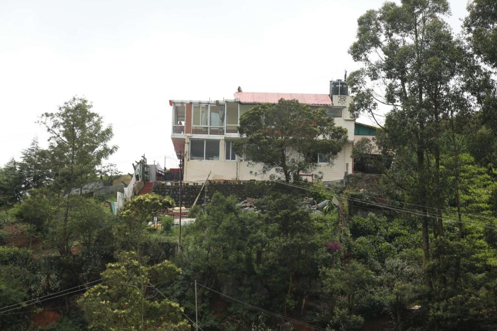 a house on top of a hill with trees at sunshine retreat in Coonoor
