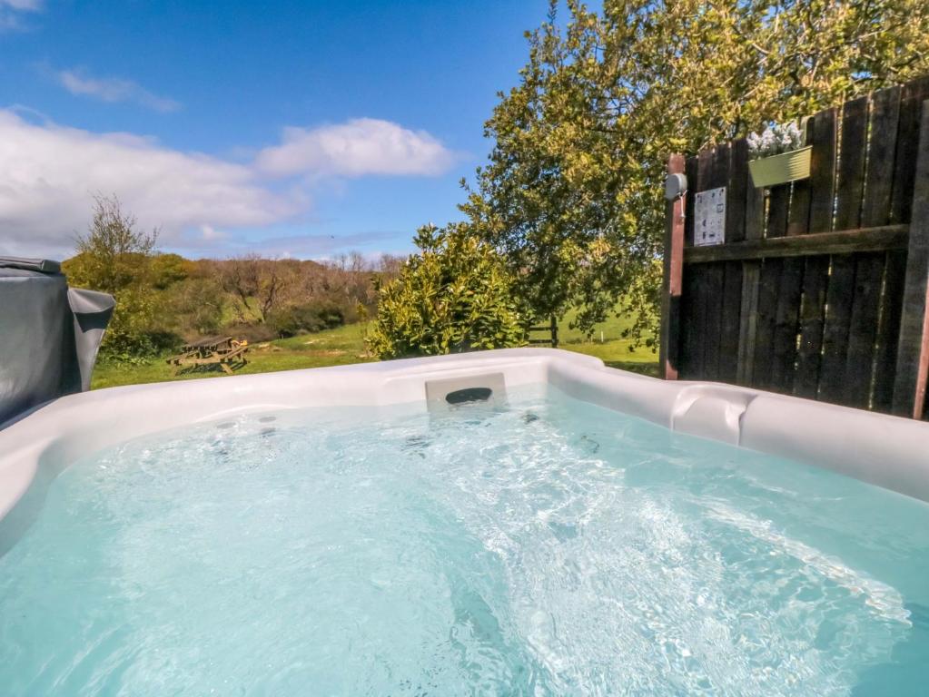a hot tub in a backyard with a fence at Carters in Staintondale