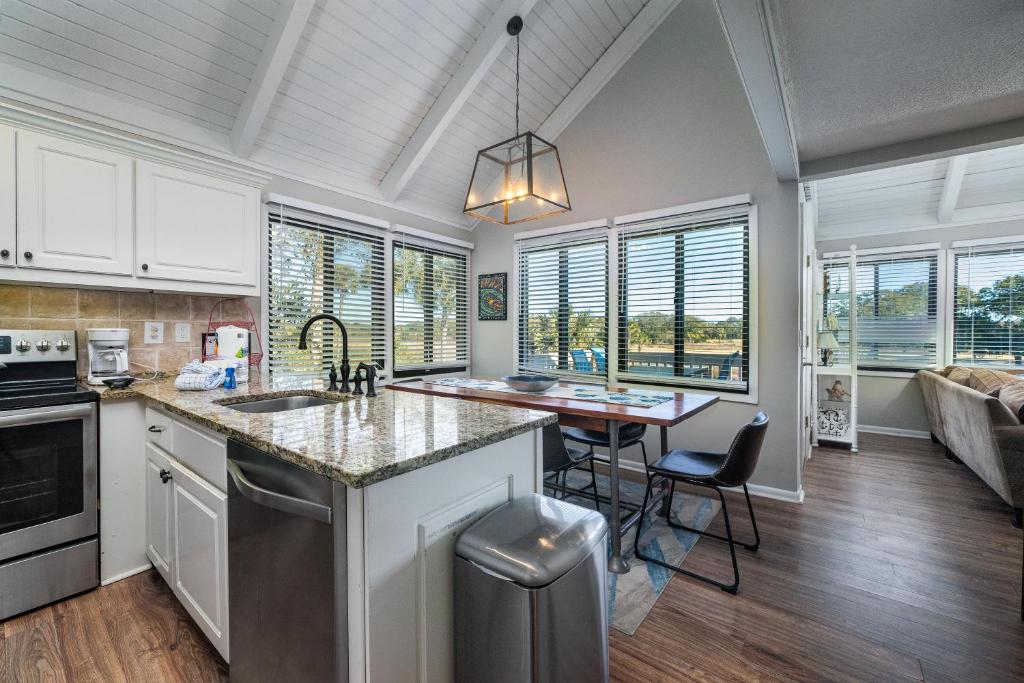 a kitchen with a sink and a table with chairs at 815 Treeloft Cottage in Seabrook Island