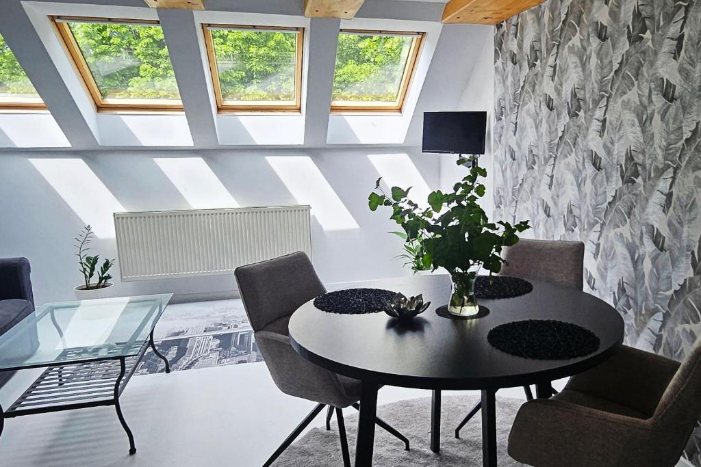 a living room with a black table and chairs at Apartmán u pilotky in Poděbrady