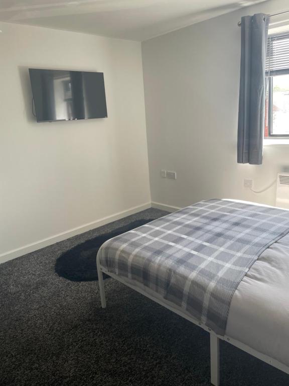 a bedroom with a bed and a tv on the wall at Jayden house in Middlesbrough