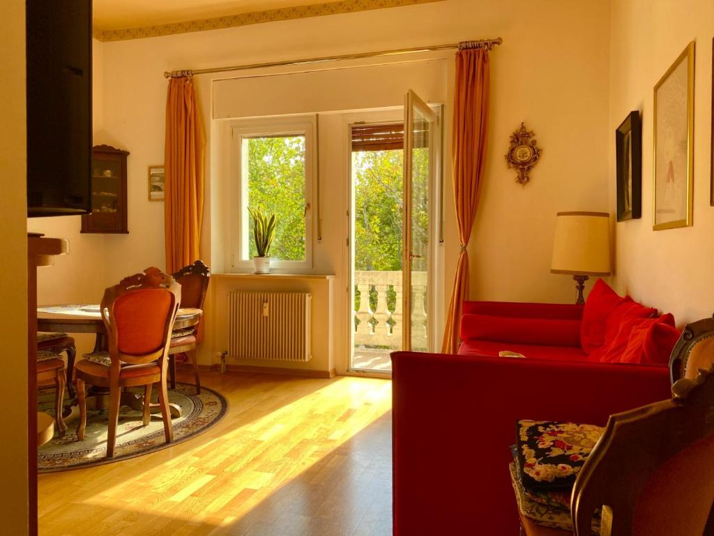 a living room with a red couch and a table at Spazioso e accogliente nel centro di Merano in Merano