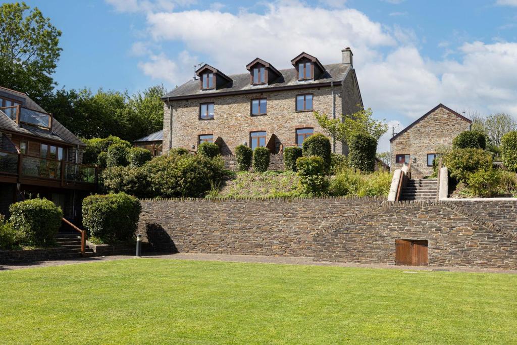 a large brick house on top of a stone wall at Pitstop in Dartmouth