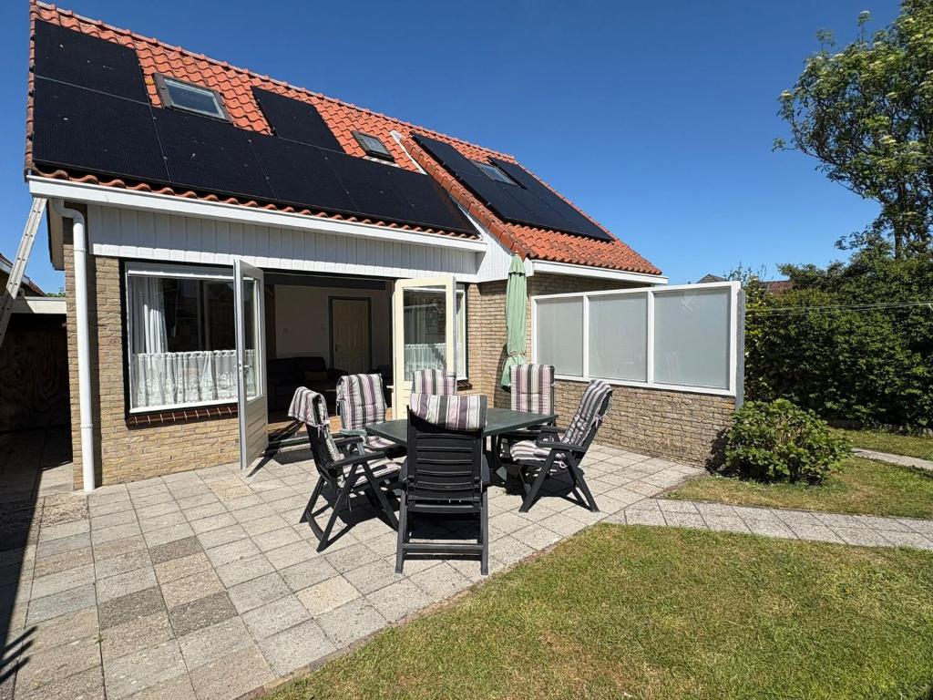 a patio with a table and chairs and a house at Verba in Hollum