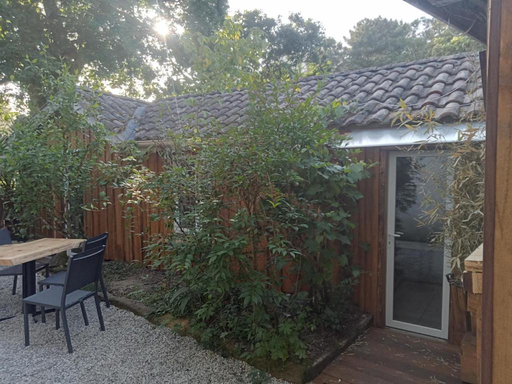 a patio with a table and chairs next to a fence at Villa René in Lacanau