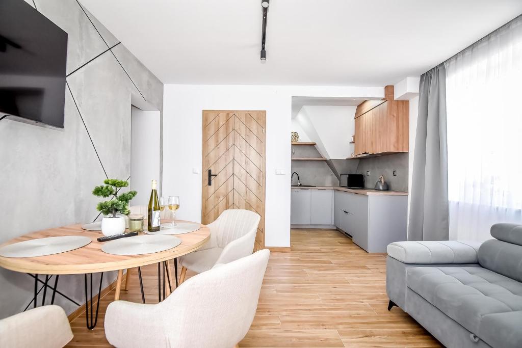 a living room with a table and chairs and a couch at Apartamenty Przystanek Bańska in Bańska Niżna