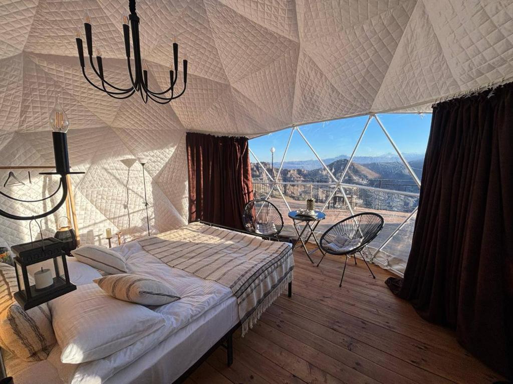 a bedroom with a bed and a large window at Trichk Resort in Goris